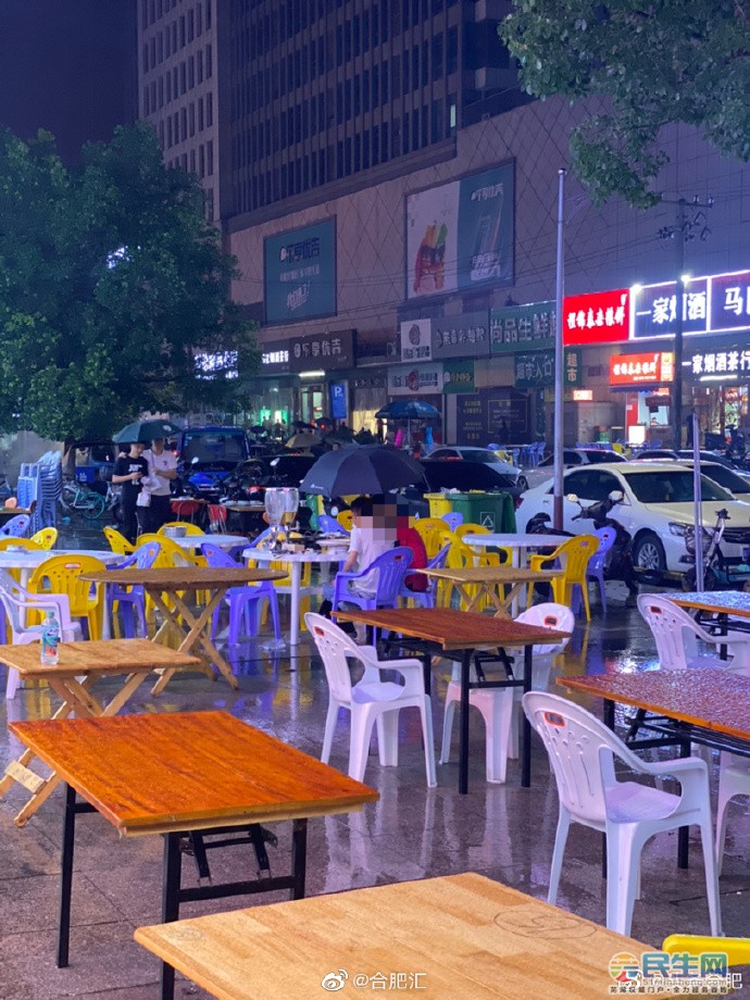安徽两男子下雨天马路边撑伞喝酒!网友:这两扎喝不完