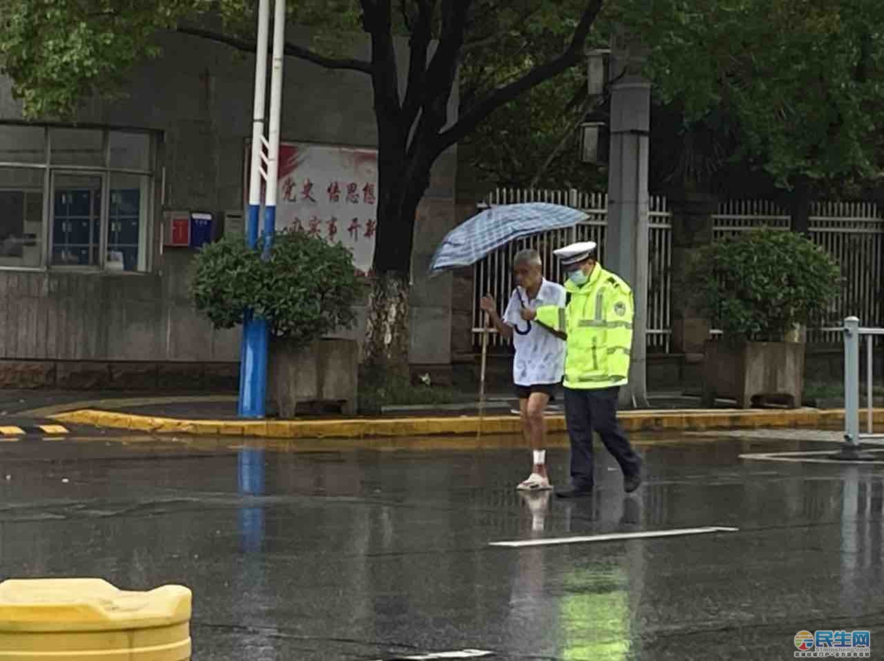 雨中交警攙扶老人過馬路