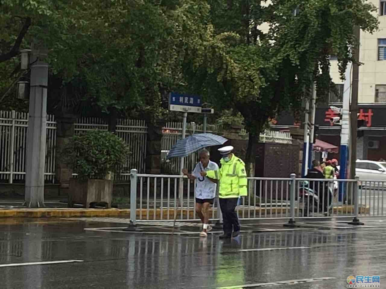 雨中交警搀扶老人过马路